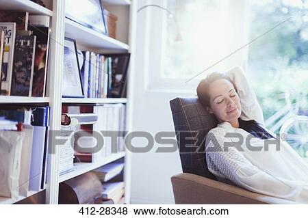 Stock Photo - Serene woman napping in armchair. Fotosearch