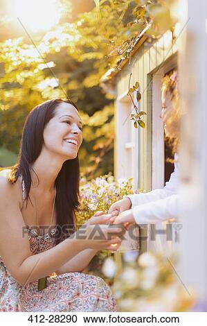 Smiling mother and daughter holding hands at playhouse View Large Photo Image Stock Image - Smiling mother and daughter holding hands at playhouse. Fotosearch