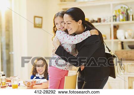 Working mother hugging daughter goodbye at breakfast table View Large Photo Image Stock Image - Working mother hugging daughter goodbye at breakfast table. Fotosearch
