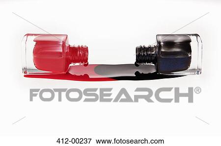 Stock Photo - Blue and coral fingernail polish spilling from bottles. Fotosearch