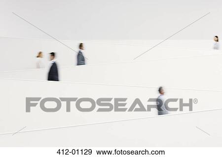 Blurred business people walking along modern staircase View Large Photo Image Stock Photo - Blurred business people walking along modern staircase. Fotosearch