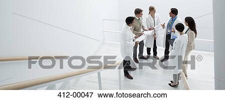 Business people and doctors meeting on landing of stairs View Large Photo Image Stock Photo - Business people and doctors meeting on landing of stairs. Fotosearch