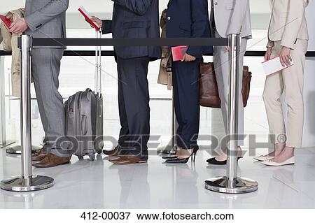 Business people standing in queue at airport View Large Photo Image Stock Photo - Business people standing in queue at airport. Fotosearch