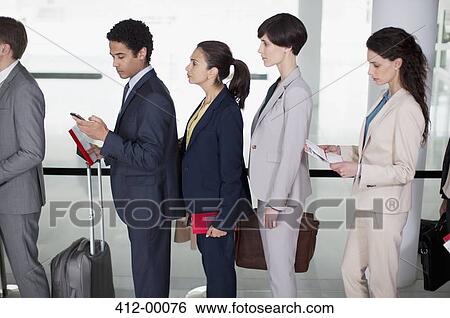 Business people standing in queue at airport View Large Photo Image Stock Photograph - Business people standing in queue at airport. Fotosearch
