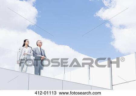 Businessman and businesswoman on balcony View Large Photo Image Stock Image - Businessman and businesswoman on balcony. Fotosearch