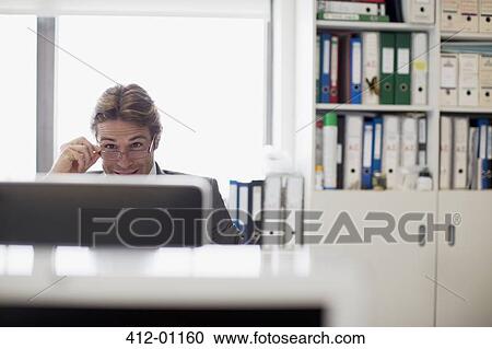 Businessman reading e-mail at computer in office View Large Photo Image Stock Image - Businessman reading e-mail at computer in office. Fotosearch