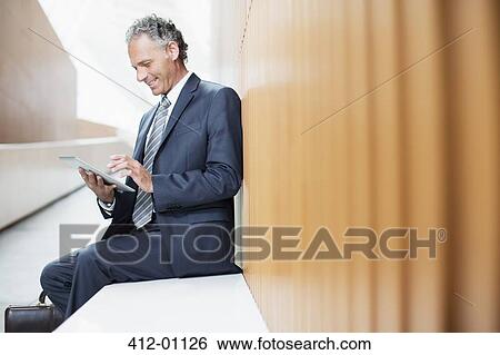 Stock Photograph - Businessman using digital tablet in office. Fotosearch