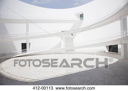 Businessman walking through modern courtyard View Large Photo Image Stock Image - Businessman walking through modern courtyard. Fotosearch