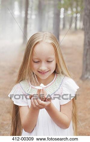 Close up of girl holding butterfly in woods View Large Photo Image Stock Photo - Close up of girl holding butterfly in woods. Fotosearch