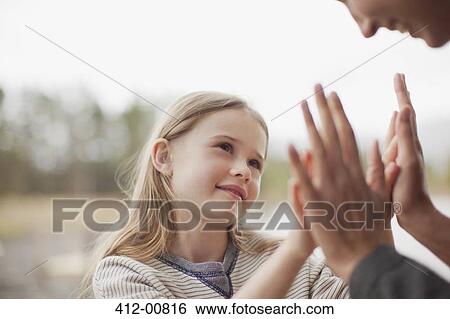 Close up of mother and daughter playing pat-a-cake View Large Photo Image Stock Photograph - Close up of mother and daughter playing pat-a-cake. Fotosearch