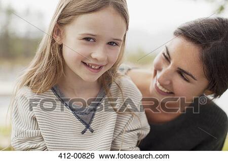 Close up portrait of smiling mother and daughter View Large Photo Image Stock Photograph - Close up portrait of smiling mother and daughter. Fotosearch