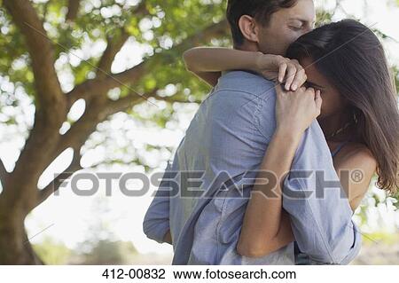 Couple hugging under tree View Large Photo Image Stock Image - Couple hugging under tree. Fotosearch