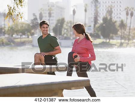 Couple stretching together in park View Large Photo Image Stock Photo - Couple stretching together in park. Fotosearch