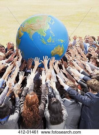 Stock Image - Crowd of business people reaching for globe. Fotosearch