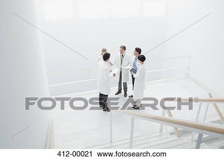 Doctors meeting on landing of stairs View Large Photo Image Stock Image - Doctors meeting on landing of stairs. Fotosearch