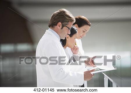 Doctors reviewing medical charts View Large Photo Image Stock Photography - Doctors reviewing medical charts. Fotosearch