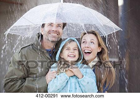 Enthusiastic family under umbrella in downpour View Large Photo Image Stock Image - Enthusiastic family under umbrella in downpour. Fotosearch