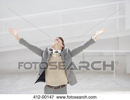 Exuberant businessman with head back and arms outstretched View Large Photo Image Stock Photo - Exuberant businessman with head back and arms outstretched. Fotosearch