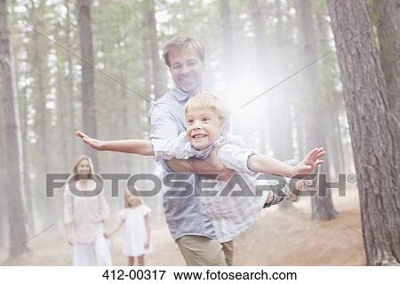 Father flying son in sunny woods View Large Photo Image Stock Photo - Father flying son in sunny woods. Fotosearch