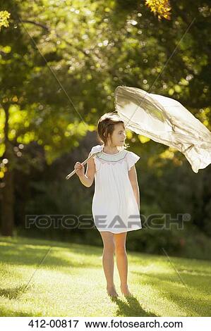 Girl carrying butterfly net in grass View Large Photo Image Stock Photo - Girl carrying butterfly net in grass. Fotosearch