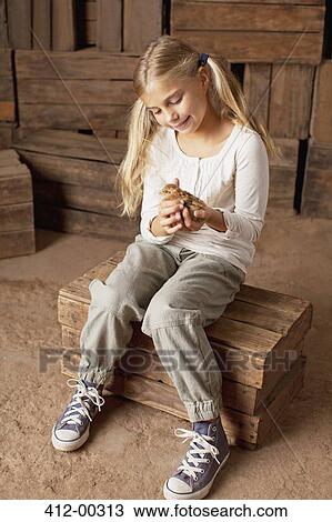 Girl holding chick in barn View Large Photo Image Stock Image - Girl holding chick in barn. Fotosearch