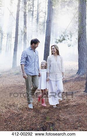 Happy family holding hands and walking in woods View Large Photo Image Stock Image - Happy family holding hands and walking in woods. Fotosearch