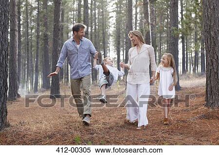 Happy family holding hands and walking in woods View Large Photo Image Stock Photography - Happy family holding hands and walking in woods. Fotosearch