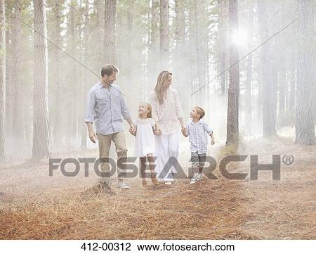 Happy family walking in sunny woods View Large Photo Image Stock Image - Happy family walking in sunny woods. Fotosearch