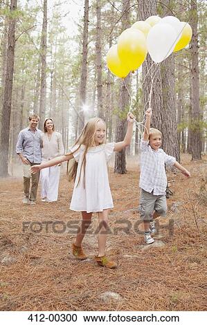 Happy family with balloons in woods View Large Photo Image Stock Image - Happy family with balloons in woods. Fotosearch
