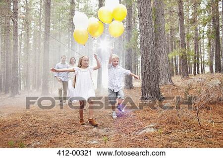 Happy family with balloons in woods View Large Photo Image Stock Image - Happy family with balloons in woods. Fotosearch