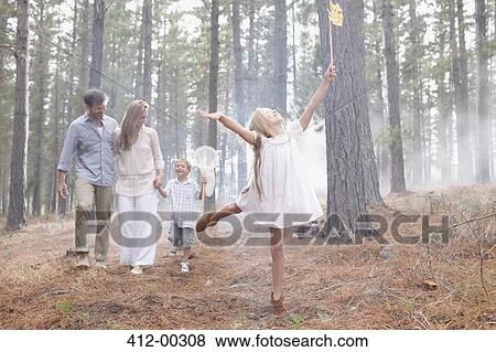 Stock Photo - Happy family with butterfly nets in sunny woods. Fotosearch