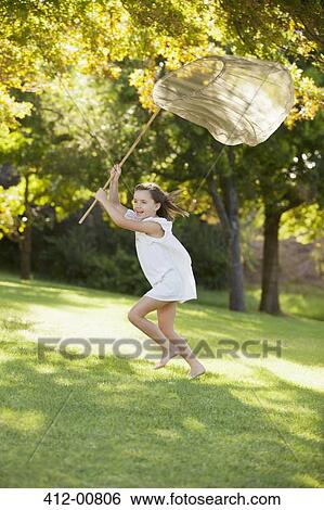 Happy girl running with butterfly net in grass View Large Photo Image Stock Photograph - Happy girl running with butterfly net in grass. Fotosearch