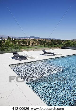 Lounge chairs and swimming pool View Large Photo Image Stock Photograph - Lounge chairs and swimming pool. Fotosearch