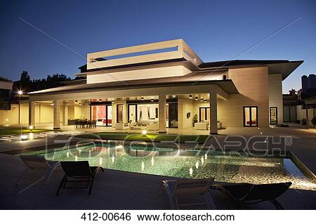Luxury house and swimming pool illuminated at night View Large Photo Image Stock Photograph - Luxury house and swimming pool illuminated at night. Fotosearch