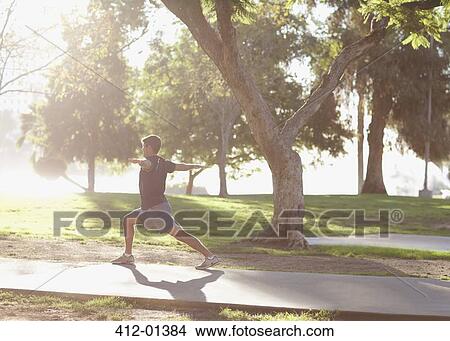 Picture - Man practicing yoga in park. Fotosearch