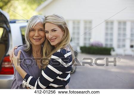 Stock Photograph - Mother and daughter hugging outdoors. Fotosearch