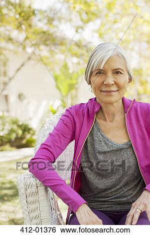 Older woman sitting outdoors View Large Photo Image Stock Photograph - Older woman sitting outdoors. Fotosearch