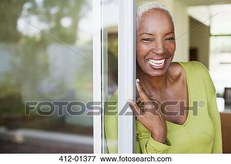 Stock Photo - Older woman smiling in doorway. Fotosearch