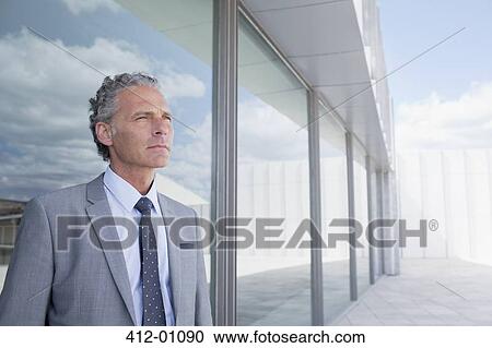 Pensive businessman outside building View Large Photo Image Stock Image - Pensive businessman outside building. Fotosearch