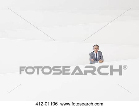 Stock Photograph - Portrait of confident businessman leaning on railing of modern staircase. Fotosearch
