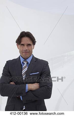 Stock Photograph - Portrait of confident businessman with arms crossed. Fotosearch