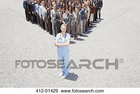 Portrait of confident nurse with business people in background View Large Photo Image Stock Photo - Portrait of confident nurse with business people in background. Fotosearch