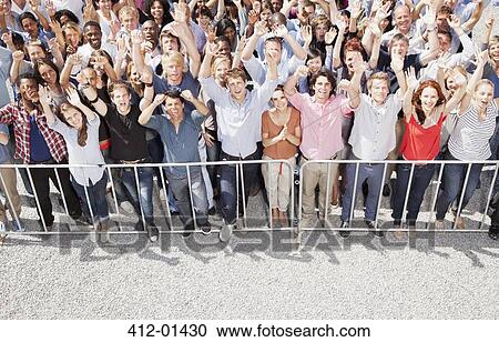 Portrait of crowd cheering with arms raised View Large Photo Image Stock Image - Portrait of crowd cheering with arms raised. Fotosearch
