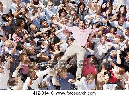 Stock Photograph - Portrait of enthusiastic man crowd surfing. Fotosearch