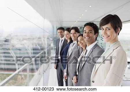 Portrait of smiling business people at window in conference room View Large Photo Image Stock Image - Portrait of smiling business people at window in conference room. Fotosearch