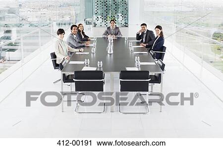 Portrait of smiling business people at conference room table View Large Photo Image Stock Image - Portrait of smiling business people at conference room table. Fotosearch