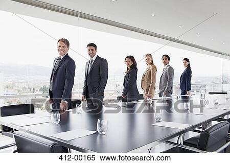 Portrait of smiling business people standing in a row at conference room window View Large Photo Image Stock Photography - Portrait of smiling business people standing in a row at conference room window. Fotosearch