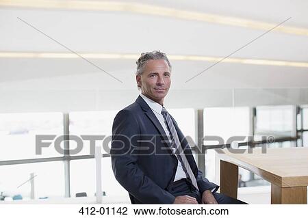 Portrait of smiling businessman at table View Large Photo Image Stock Image - Portrait of smiling businessman at table. Fotosearch