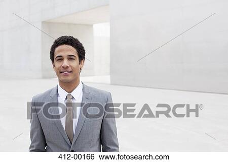 Portrait of smiling businessman standing outside cultural center View Large Photo Image Stock Photograph - Portrait of smiling businessman standing outside cultural center. Fotosearch