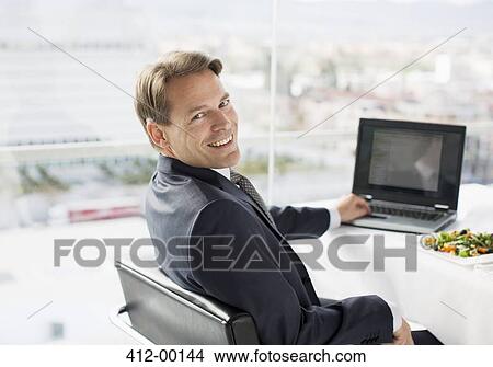 Portrait of smiling businessman with laptop and lunch View Large Photo Image Picture - Portrait of smiling businessman with laptop and lunch. Fotosearch